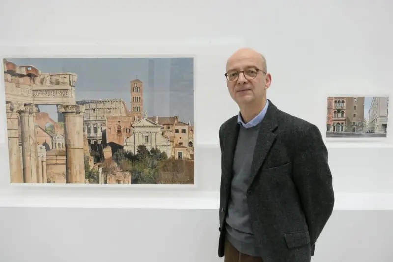 Der Fotograf Maximilian Meisse vor seinen Werken im Baukunstarchiv NRW. – Foto: Melina Beierle/ Architektenkammer NRW