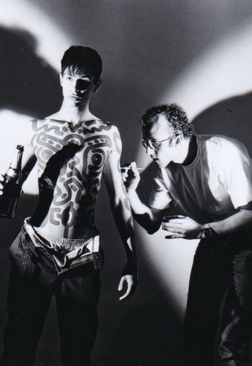 Keith Haring ritratto da Patrick Sarfati mentre dipinge il corpo di un modello a Parigi nel 1985. Foto in mostra alla Galleria David Guiraud